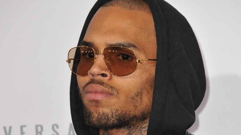 Chris Brown wearing sunglasses and hood