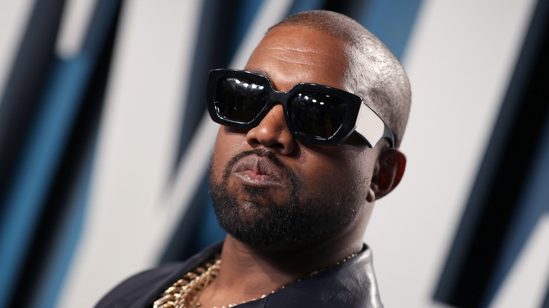 Kanye West at an event, wearing sunglasses