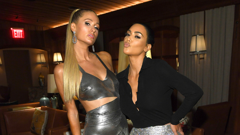 Kim Kardashian and Paris Hilton, both posing