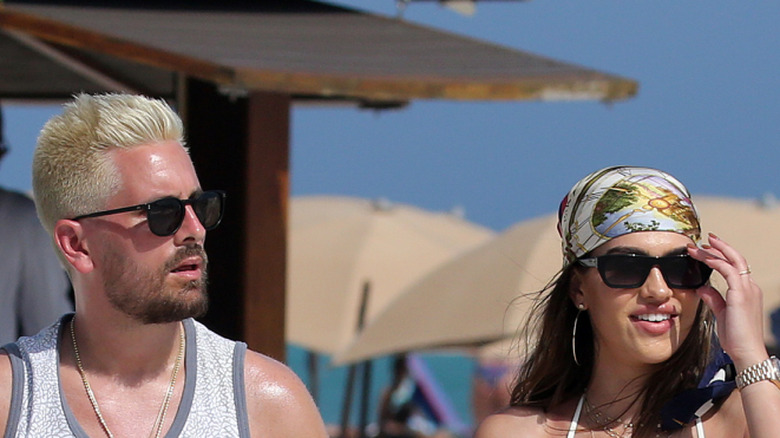 Scott Disick walking by pool with Amelia Hamlin