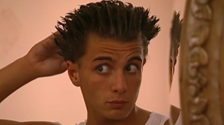 A Gotti son looking at his gelled hair in the mirror