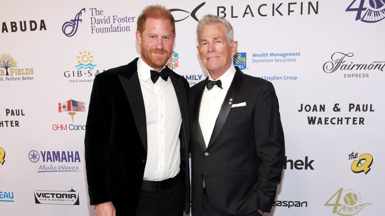 Prince Harry and David Foster posing together in tuxedos at The David Foster Foundation's 40th anniversary gala.