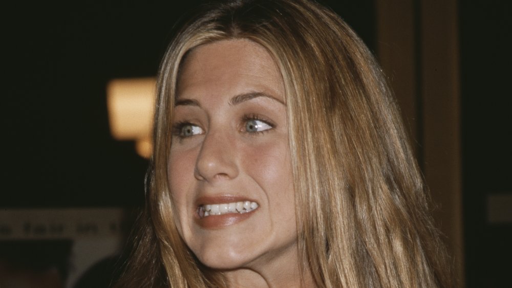 Jennifer Aniston grimacing and shrugging