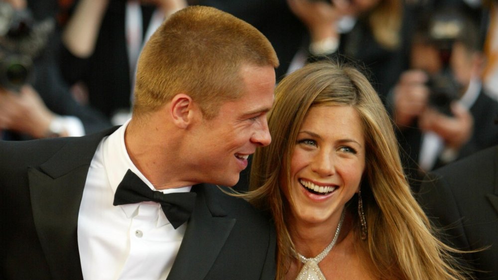 Brad Pitt and Jennifer Aniston holding hands and laughing at the Troy premiere in 2004