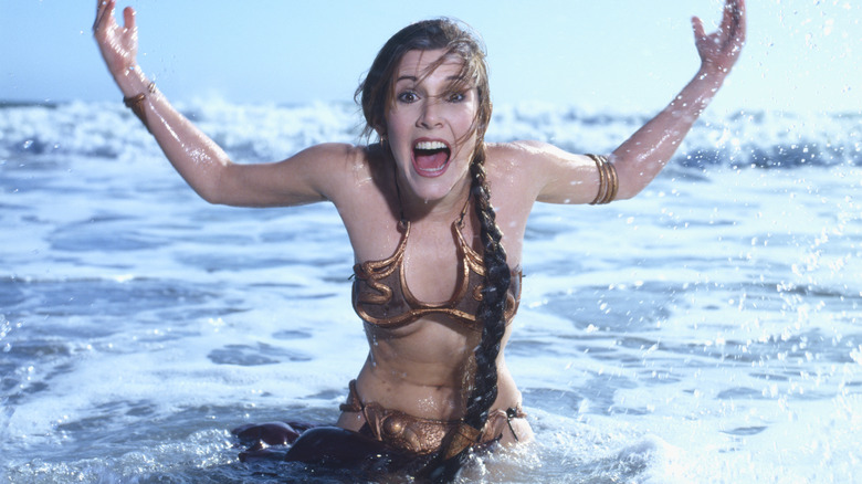 Carrie Fisher splashing in the water in her Princess Leia bikini outfit.