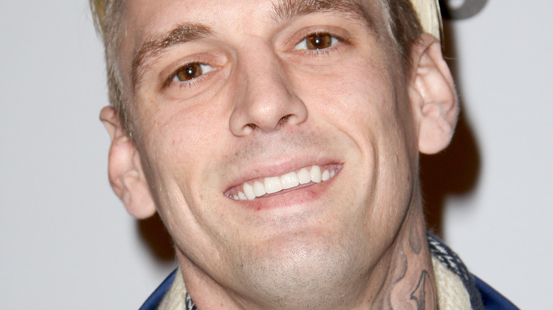 Aaron Carter smiles in a blue outfit.