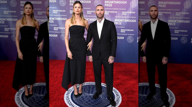 Behati Prinsloo and Adam Levine pose awkwardly in all black on 2024 red carpet.