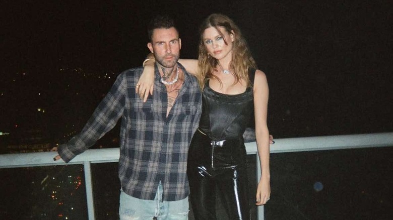 Behati Prinsloo and Adam Levine pose together in Miami at night in 2021.