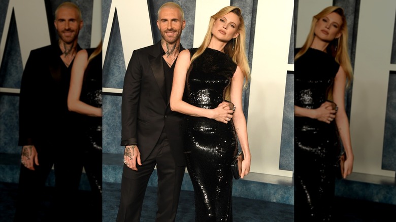 Adam Levine and Behati Prinsloo pose in all black at 2023 Oscar Party red carpet.