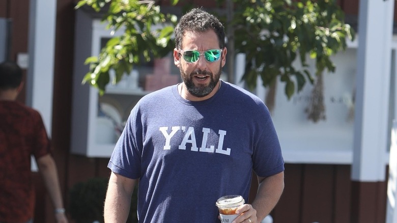 Adam Sandler walking with a coffee