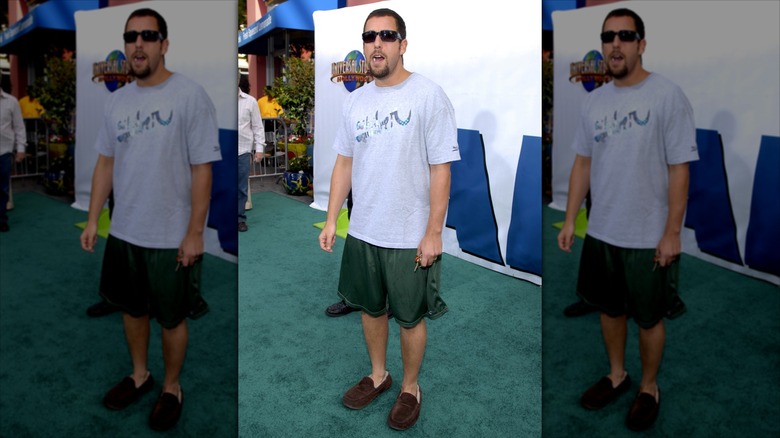 Adam Sandler standing, chewing gum