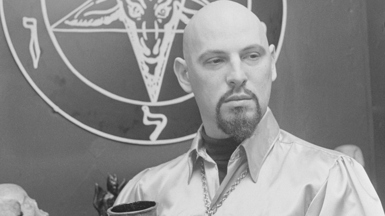 Anton LaVey posing with a chalice.