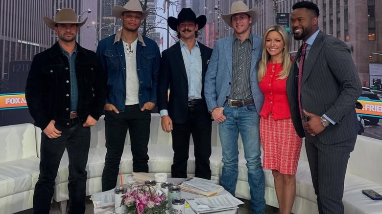 Ainsley Earhardt wearing a red sweater and pink patterned skirt on Fox & Friends