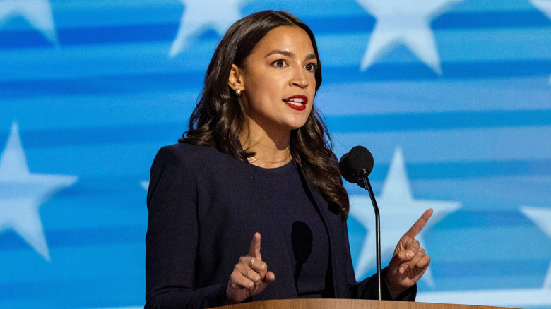 Alexandria Ocasio-Cortez speaking with a serious expression