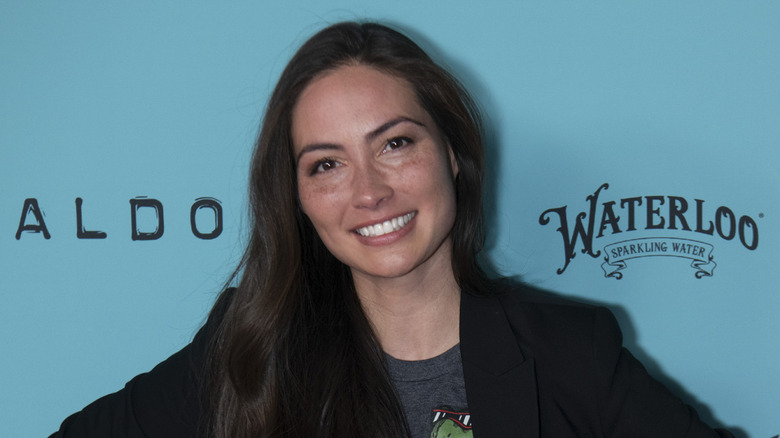 Caitlin McHugh smiling in front of a blue backdrop