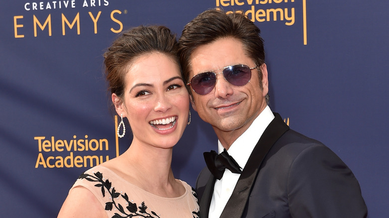 Caitlin McHugh and John Stamos smiling in formalwear at the Emmys