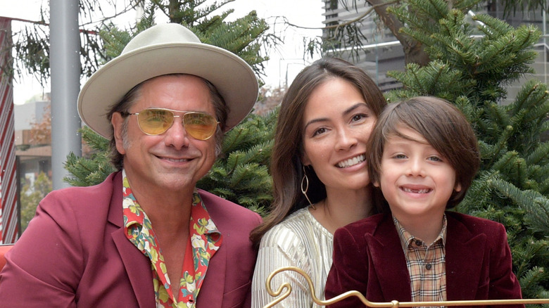 John Stamos and Caitlin McHugh posing together with son Billy on Caitlin's lap