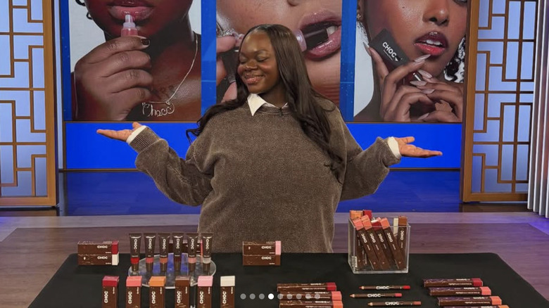 Cori Broadus smiling with her makeup products