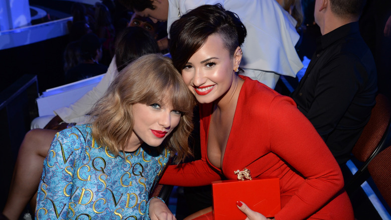 Taylor Swift and Demi Lovato posing at an awards show