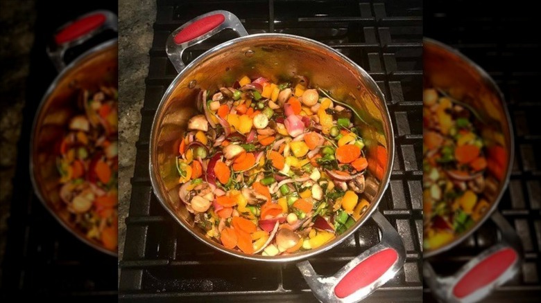 A pot on the stove with vegetables