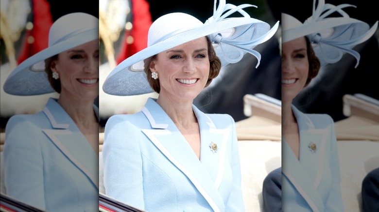 Princess Catherine smiling in a blue hat and coat dress during Trooping the Colour 2026.