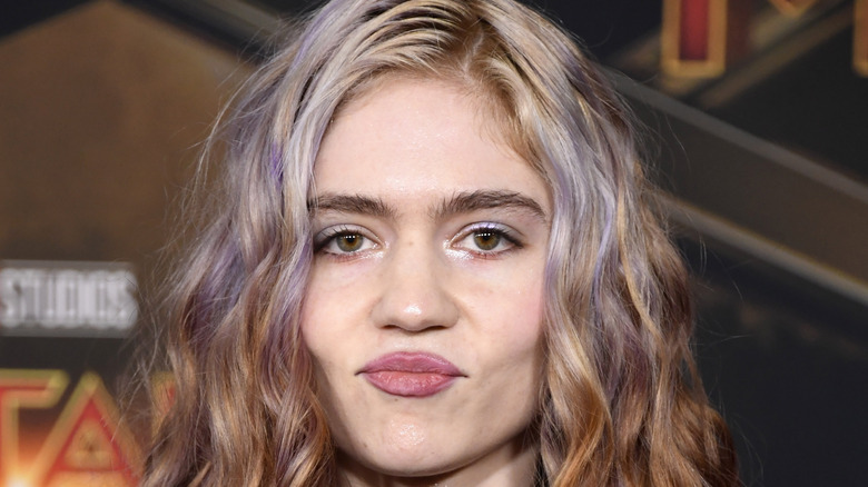 Grimes with lips pressed together