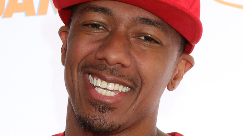 Nick Cannon smiling in red cap