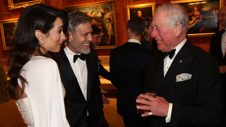 Amal Clooney and George Clooney speaking to King Charles