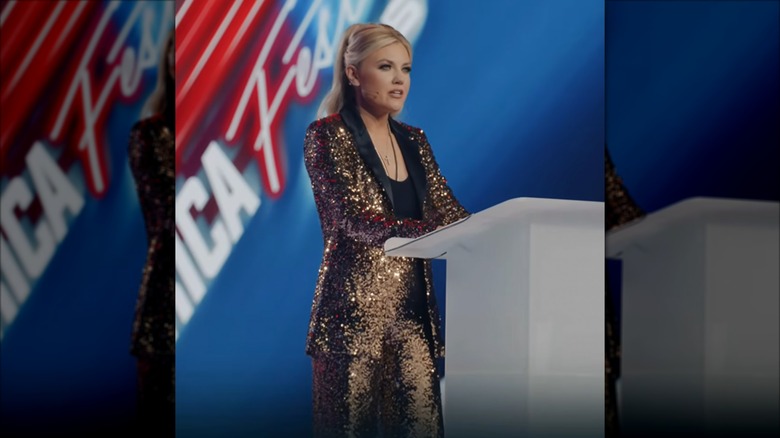 Erika Kirk wearing a sequin pantsuit at a podium