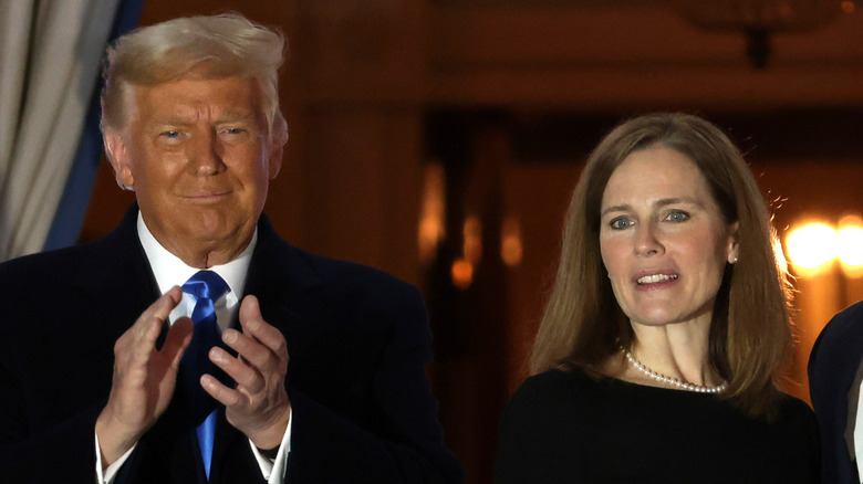Amy Coney Barrett posing alongside Donald Trump