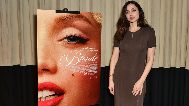 Ana de Armas posing with 'Blonde' poster
