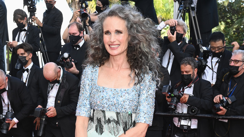 Andie MacDowell, smiling, showing off gray curly hair