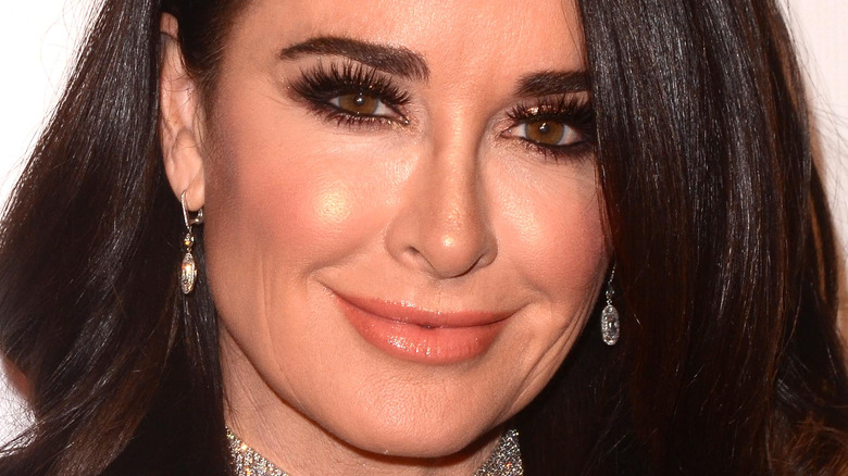 Kyle Richards smiles in silver jewelry 