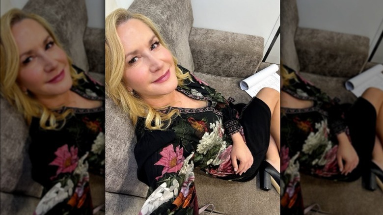 Angela Kinsey seated on a couch on the set of "Shifting Gears."