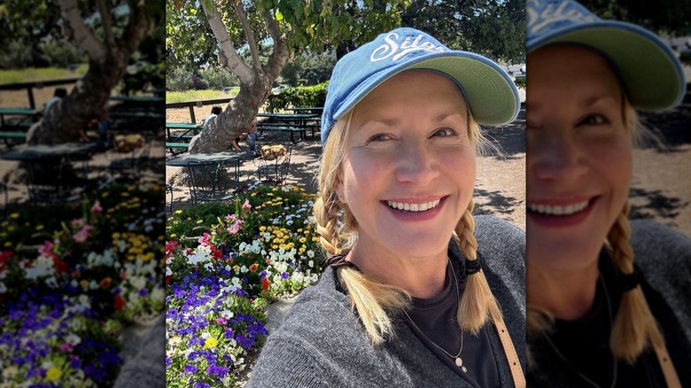 Angela Kinsey taking a selfie outside in braided pigtails and a ballcap.
