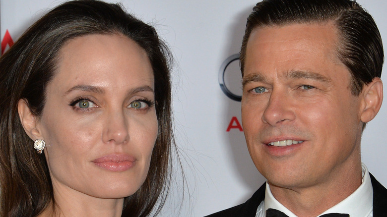 Angelina Jolie staring Brad Pitt smiling slicked back hair