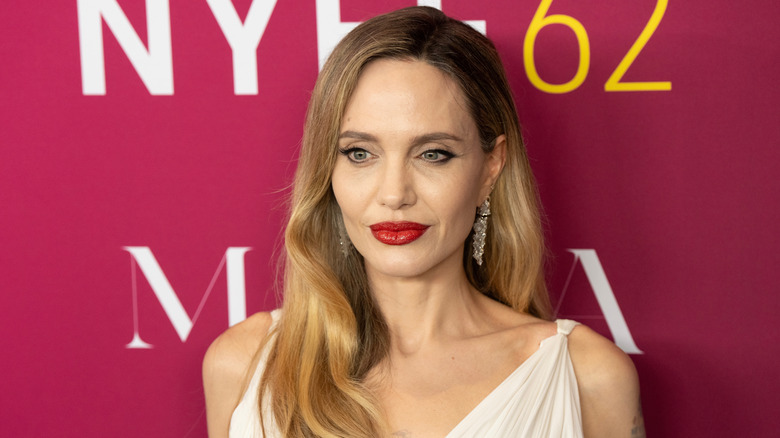 Angelina Jolie posing with bright red lip color.