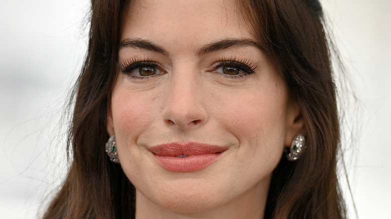 Anne Hathaway smiles in a blue dress