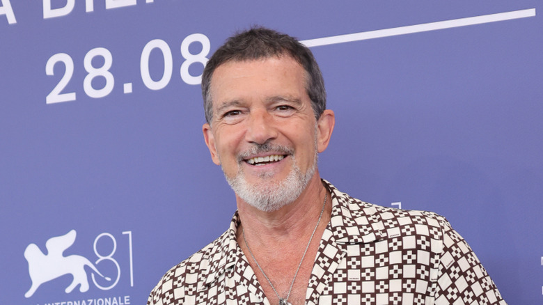 Antonio Banderas smiling while posing at an event in a patterned shirt