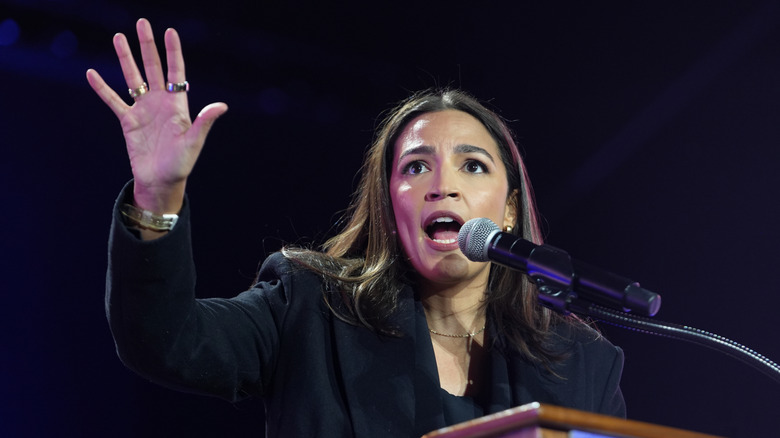 Alexandria Ocasio-Cortez speaking into a microphone