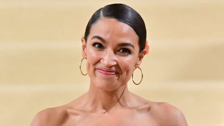 Alexandria Ocasio-Cortez wearing gold hoop earrings with her hair pulled back at the Met Gala