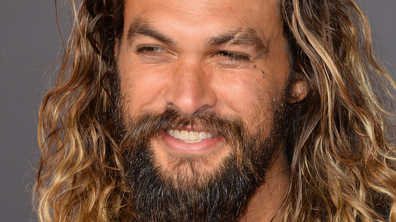 Jason Momoa on red carpet with blonde brown hair