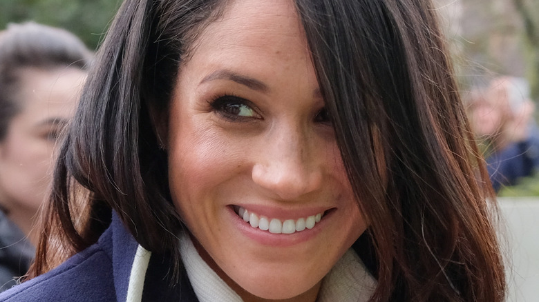 Meghan Markle looking to the side smiling