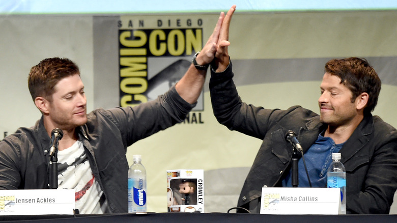 Jensen Ackles and Misha Collins high-fiving at ComicCon