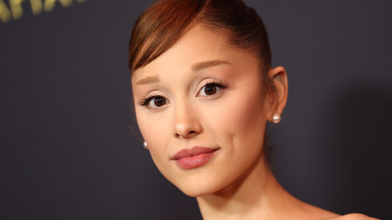 Ariana Grande close up with small brows and her hair pulled back.