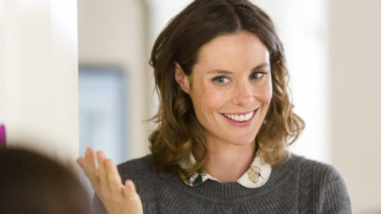 Ashley Williams smiling and gesturing with her hands in "October Kiss"