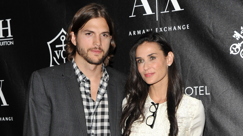 Ashton Kutcher and Demi Moore posing for photos on red carpet.