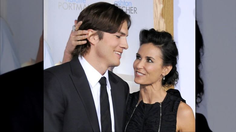 Demi Moore grabbing the back of Ashton Kutcher's head while wearing all black.