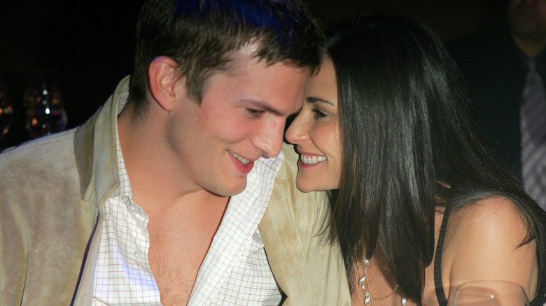 Ashton Kutcher and Demi Moore smiling with their faces close together.