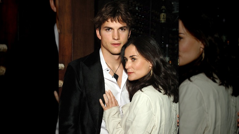 Ashton Kutcher embracing Demi Moore with her head angled.